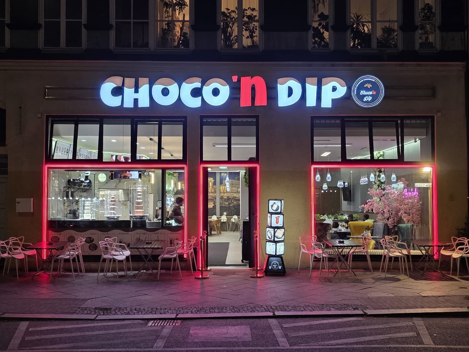 Die beleuchtete Fassade von Choco 'n Dip in der Badstraße 35 bei Nacht